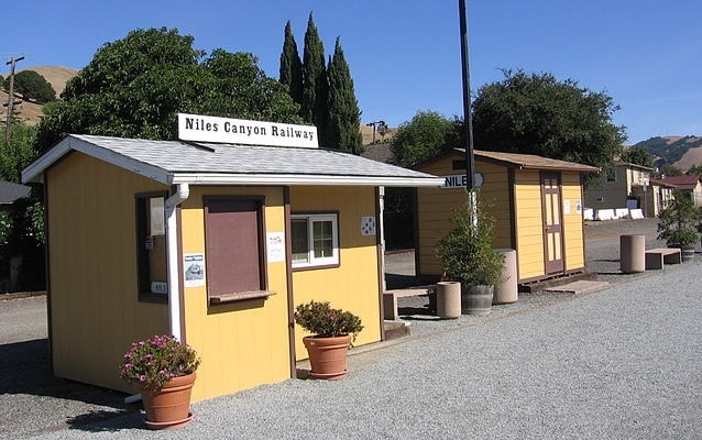 The Niles boarding platform of the Niles Canyon Railway – two small yellow buildings. 