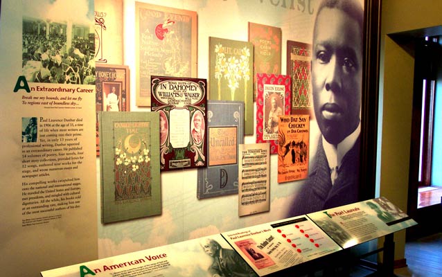 Large print covers of books on a display with a large face of a black author on the right