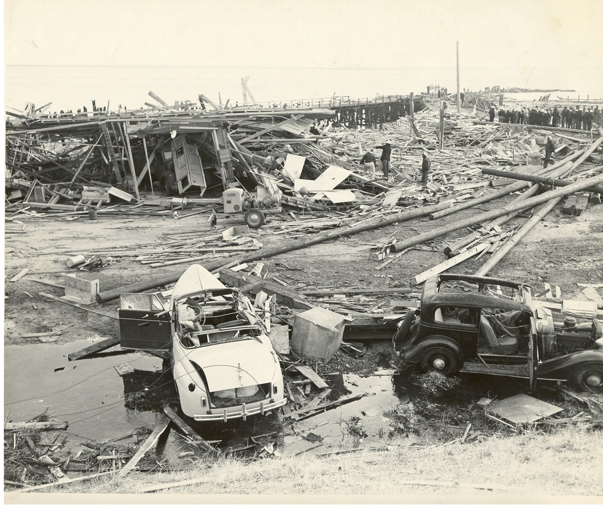 Historic Black and white photo of the disaster aftermath. Two cars and a lot of debris from buildings.
