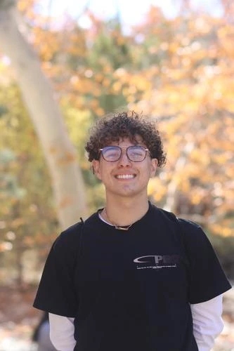 portrait of young man in front of fall foliage