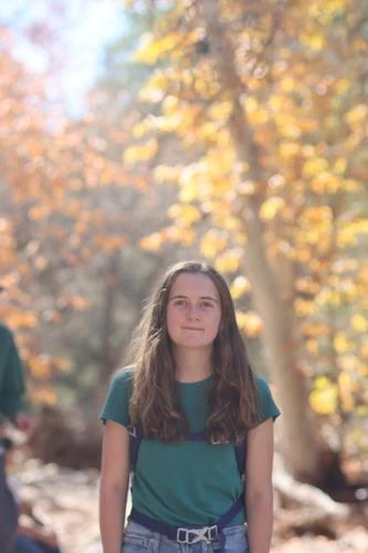 portrait of young woman in front of fall foliage