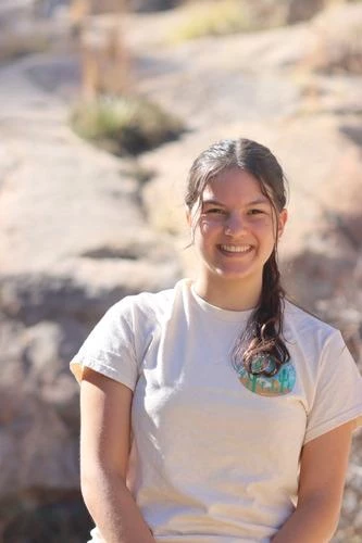 portrait of young woman in front of bedrock slope