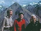 three men standing on a mountain top