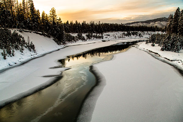 a river surrounded by snow