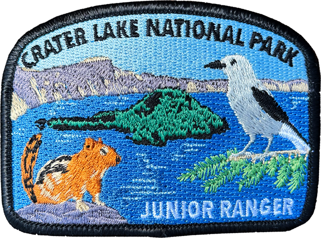 Crater Lake Junior Ranger Patch including images of a golden-mantled ground squirrel, Clark's nutcracker, and Wizard Island in the middle of Crater Lake.
