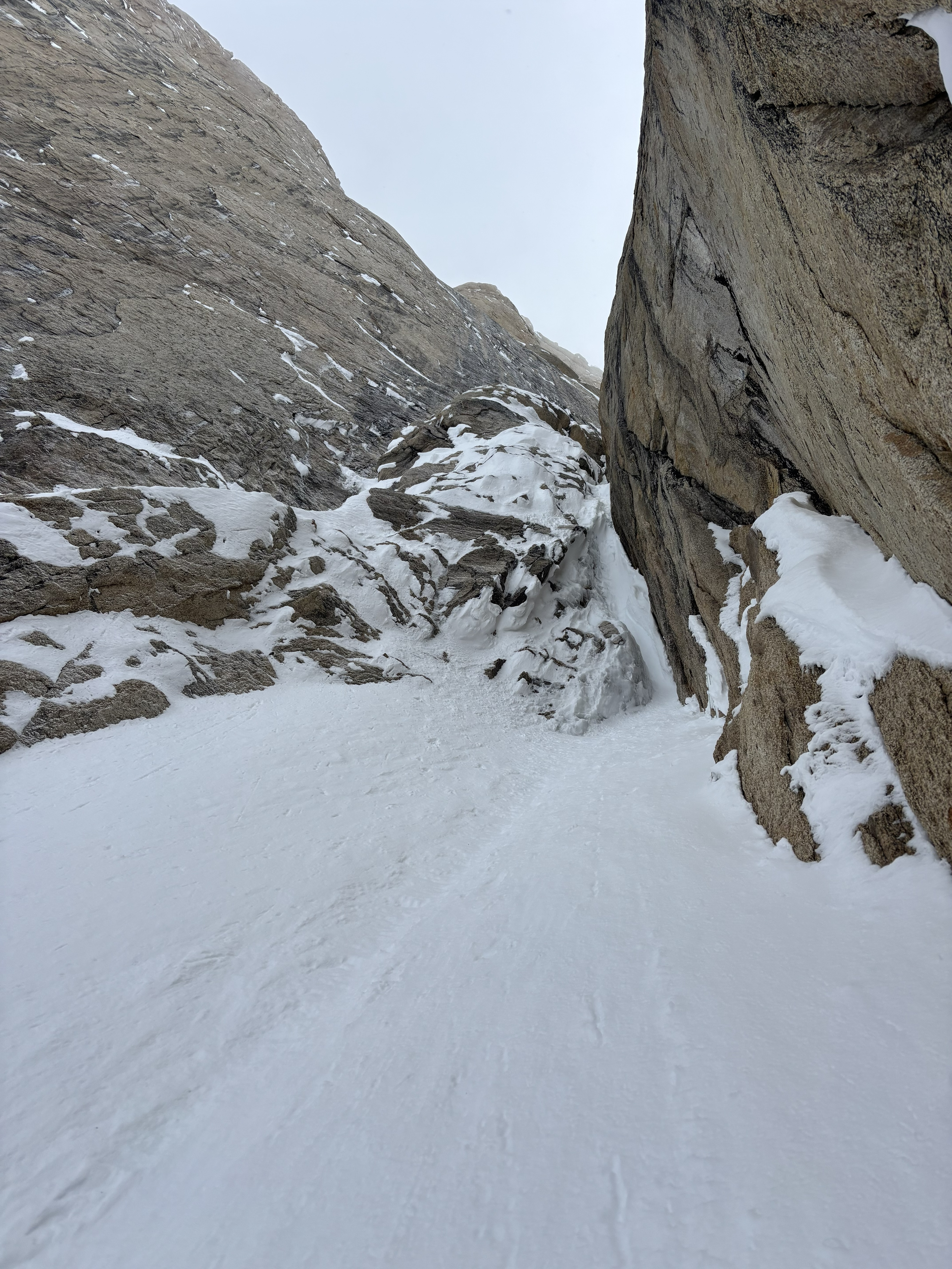 Snowy landscape between two tall rock formations