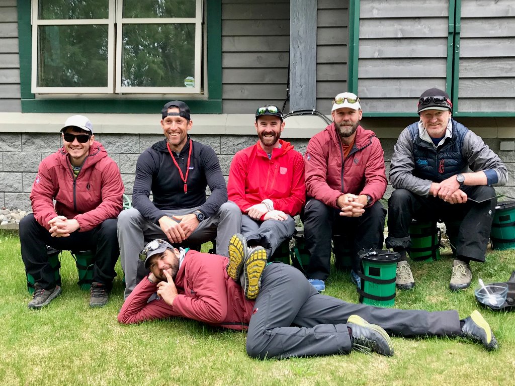 Six mountaineers sit outside the ranger station