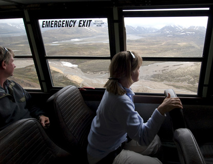 Visitors enjoy the scenic views from a park bus