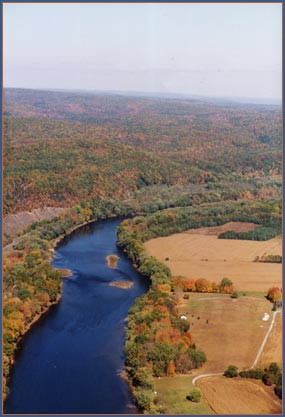 wide river in a valley of forest and farmland