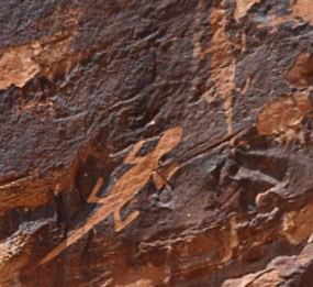 Petroglyphs of two lizards on sandstone stained with desert varnish, a dark coating found on rocks in arid regions.