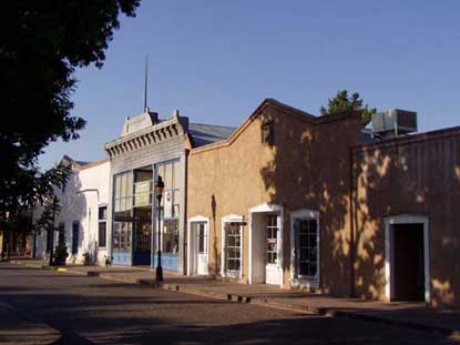 Image of historic La Mesilla, New Mexico, plaza with shade trees and adobe style buildings