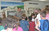 Group of children talk to a park ranger inside visitor center.