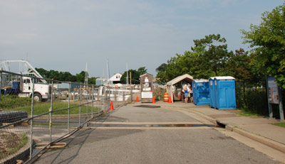 Construction site with small ticket booth and row of portable toilets.