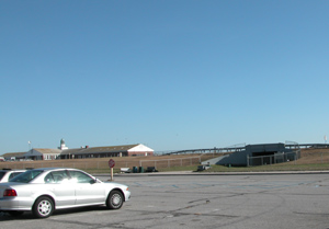 Car sits in parking lot in front of pedestrian tunnel.