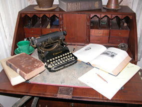 Antique typewriter on desk with open books.