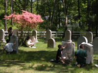 Students create grave stone rubbings in cemetery.