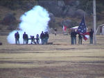 Picture of a volunteers in period dress firing the post cannon during flag lowering ceremony.