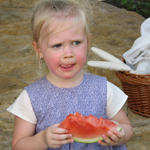 Young volunteer eats watermelon during 4th of July weekend