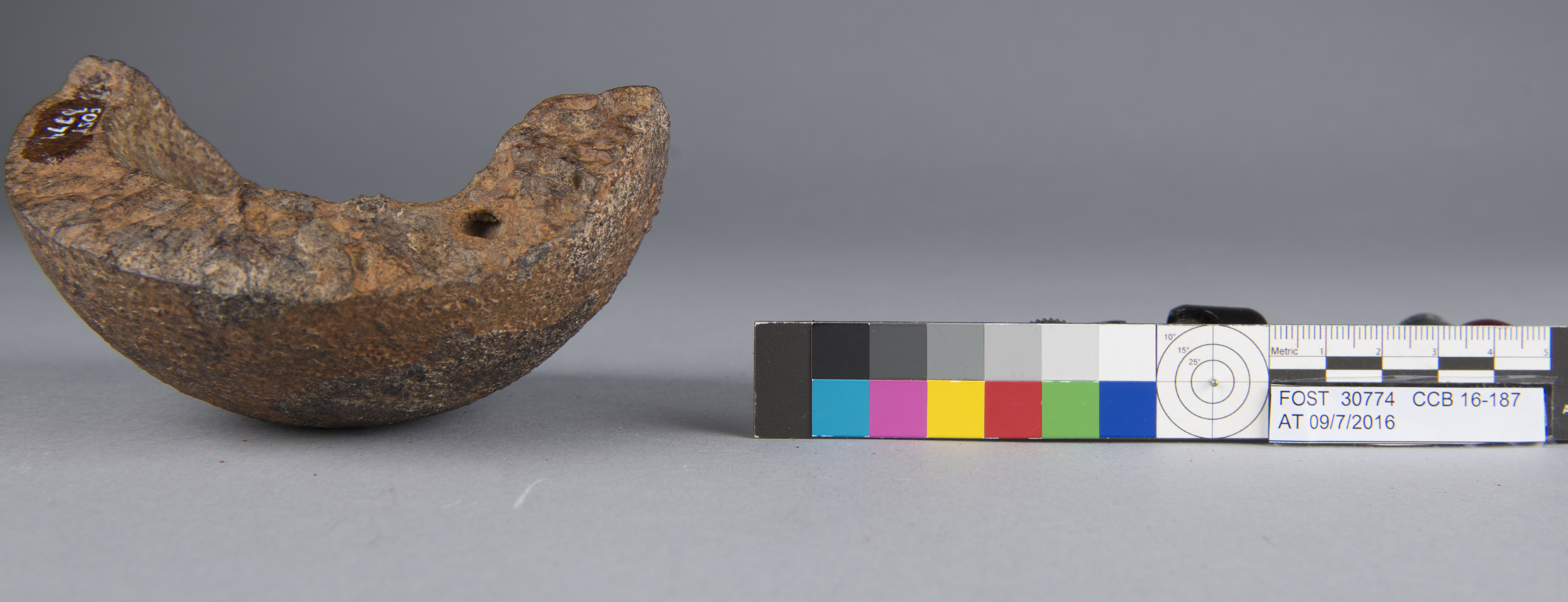 A jagged metal bowl-shaped object covered in rust. It's about half the size of a softball..