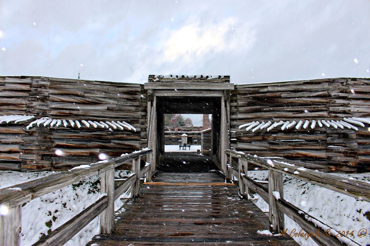 Snow softly falls in front of you as you walk across the drawbridge into the fort.