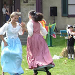 Children in period dress dancing on the Friendship Hill lawn.