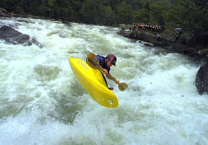 Kayaker in yellow kayak at rapid on the Gauley River.