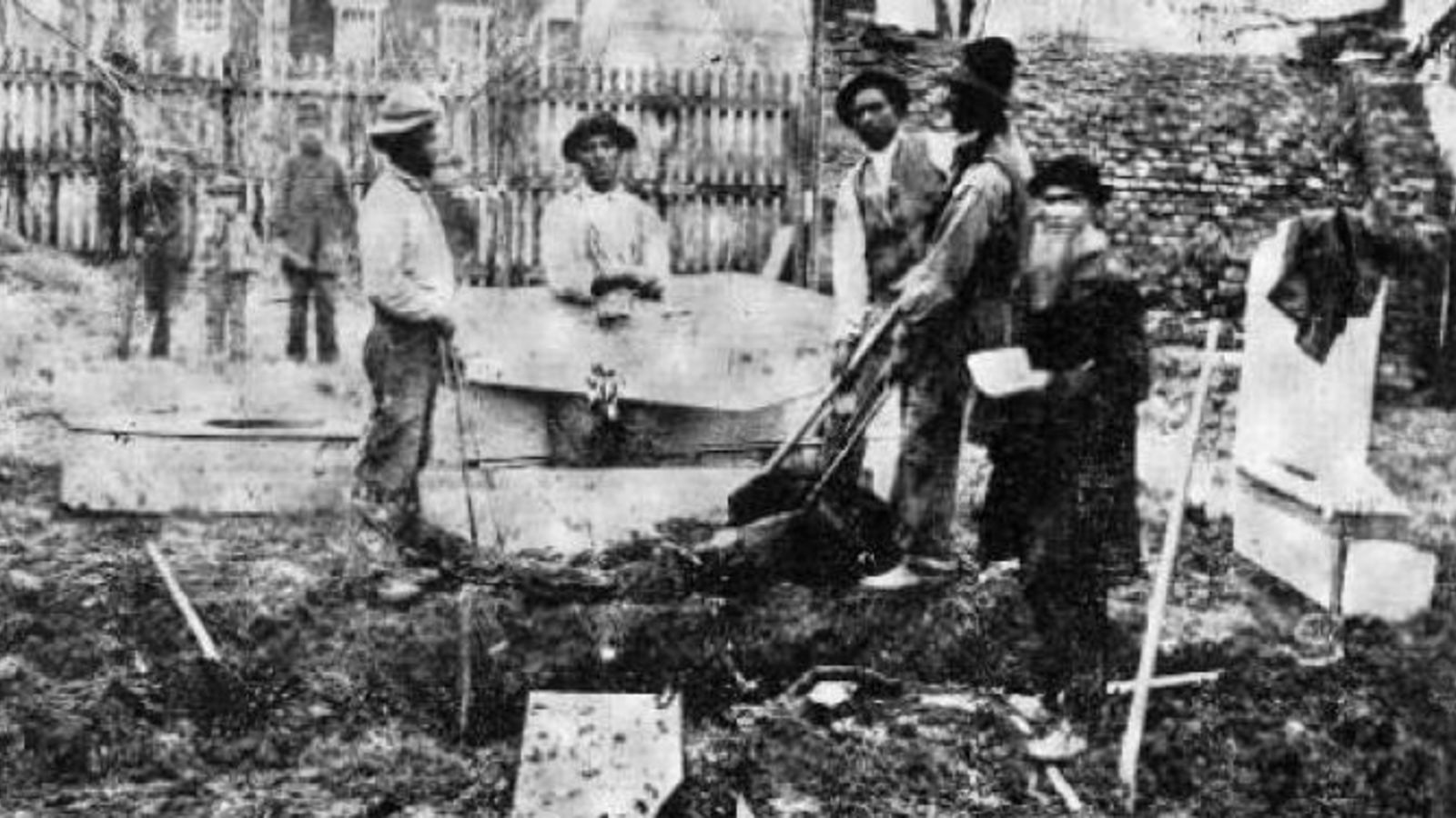 The removal of a soldier's remains by four men for reburial in the National Cemetery in Gettysburg; Samuel Weaver, who supervised the reinternments, is seen on right of image