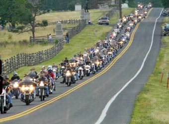 Hundreds of motorcycles drive along the Emmitsburg Road.