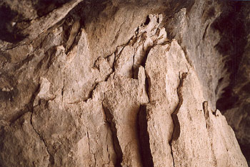 A photo of the layers of jagged edged rock that omprise the back of Cave #4