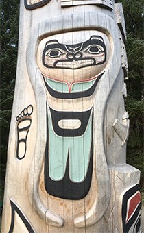 The side of the healing totem pole shows a form line design of a tsunami event at Lituya bay