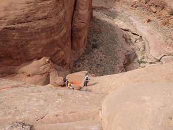 Circular canyon, people with rappelling equipment