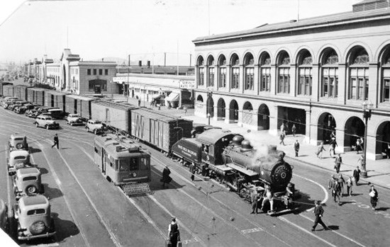 historic image of steam train and traffic in front of SF Ferry Building