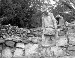 Worker resetting masonry, Tusayan Ruin 1930s