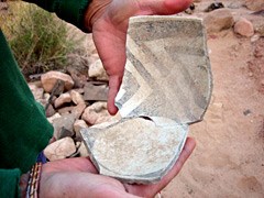 Archeologist fitting pieces broken pot together.