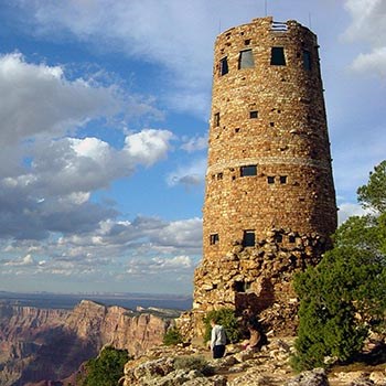 On the edge of a canyon cliff, a circular stone tower 70 feet tall