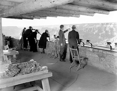 NATURALIST EDWIN MCKEEE SHOWS THE CANYON TO VISITORS FROM THE PARAPET OF YAVAPAI OBSERVATION STATION.
