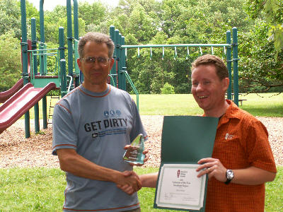 a picture of Greenbelt volunteer Mal Fordham receiving the volunteer of the year award from the American Hiking Society