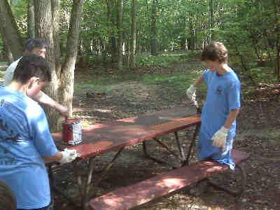Boy Scouts painting picnic tables in the Scout Loop