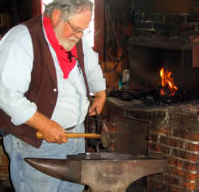 Blacksmithing demonstration with forge in the background.