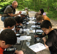 A school teacher leads a class in the park.