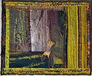 a quilted fabric wall hanging of a tree trunk and leaves