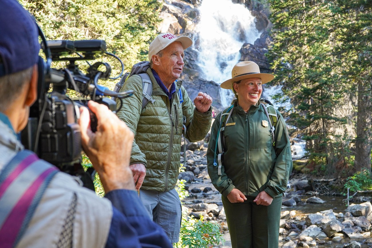 a ranger talks to a person in front of a camera