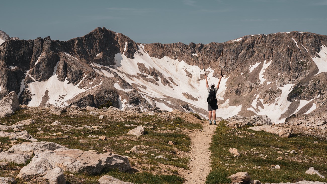Woman celebrates reaching an overlook in the Teton backcountry