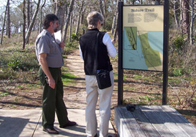 A ranger describes the trail to a park visitor. A ranger describes the trail to a park visitor.