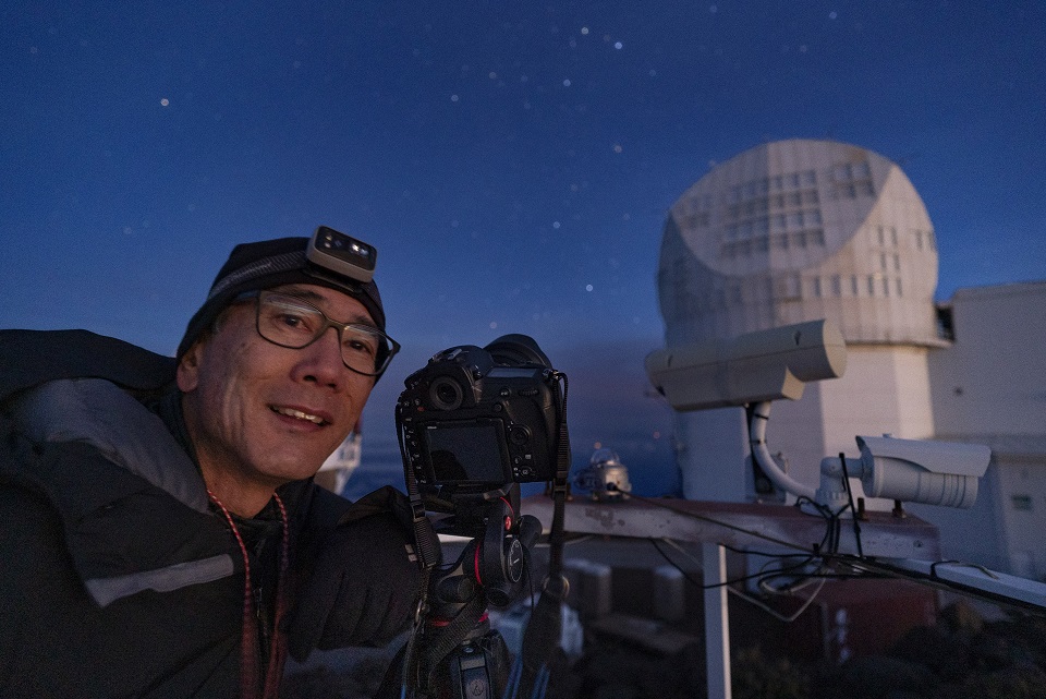 Night sky portrait of photographer Stan Honda near a space observatory on Mauna Kea volcano