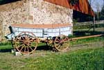 Conestoga wagon with the typical blue painted body and red wheels.