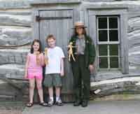 Ranger Alexis Winder and two young visitors and the Cornhusk Dolls they made Ranger Alexis Winder and two young visitors and the Cornhusk Dolls they made