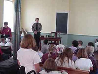 Students learning about pioneer education in a one room school house.
