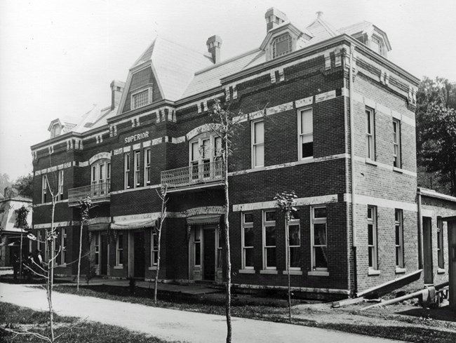 Black and white image of a two-story red brick building.