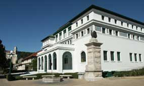 color photo of Maurice, a three-story Spanish-style white stucco building with a green tile roof